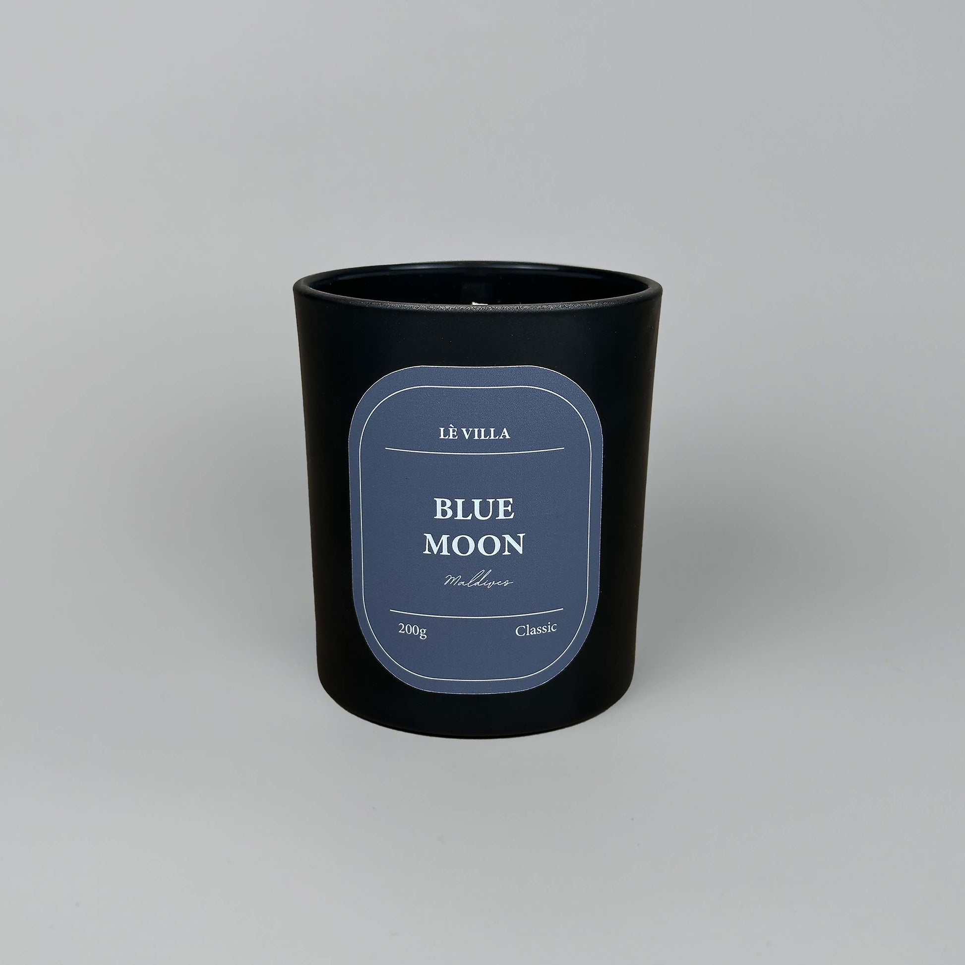 a matte black candle jar with a blue label for maldive's blue moon scent