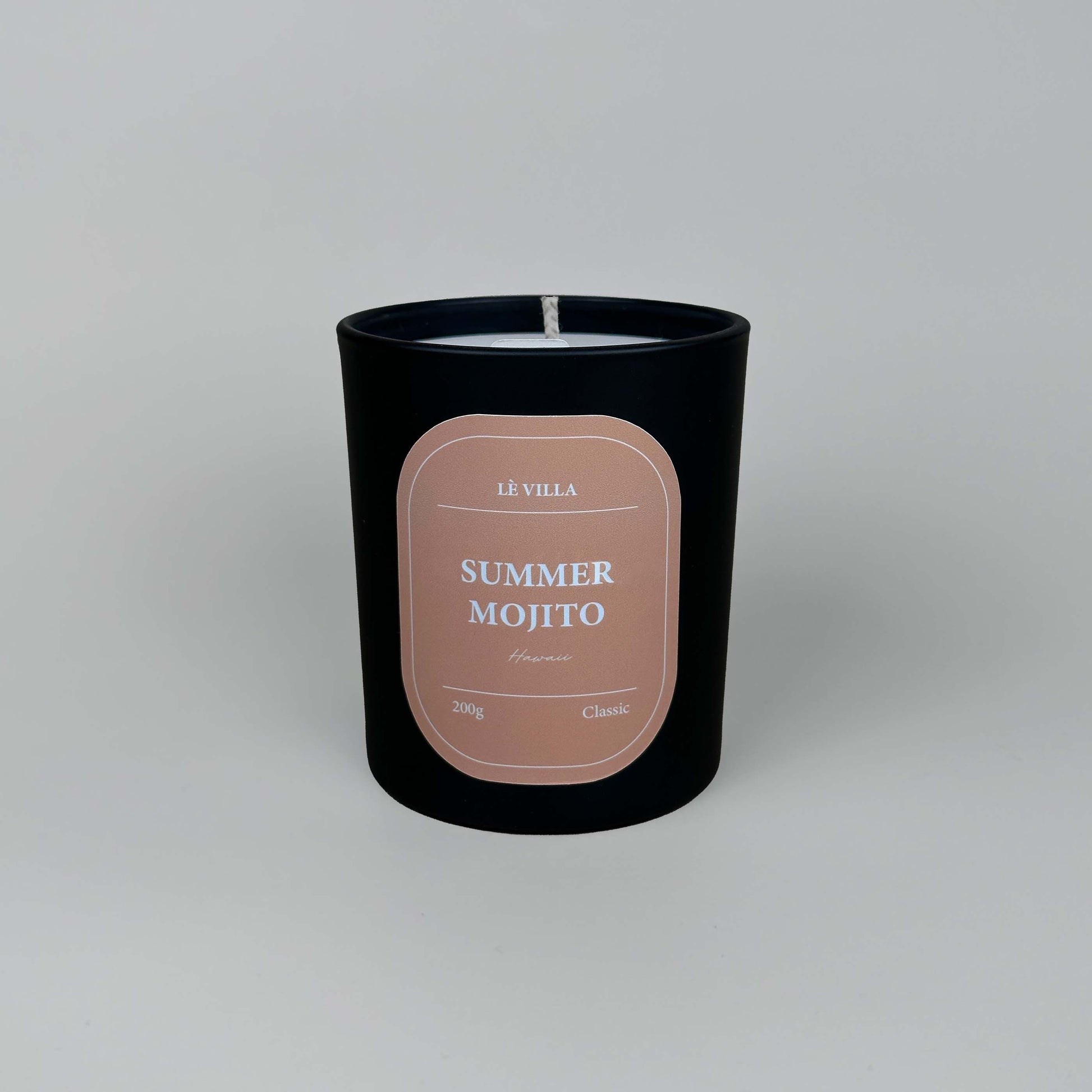 a matte black candle jar with a orange label for hawaii's summer mojito scent
