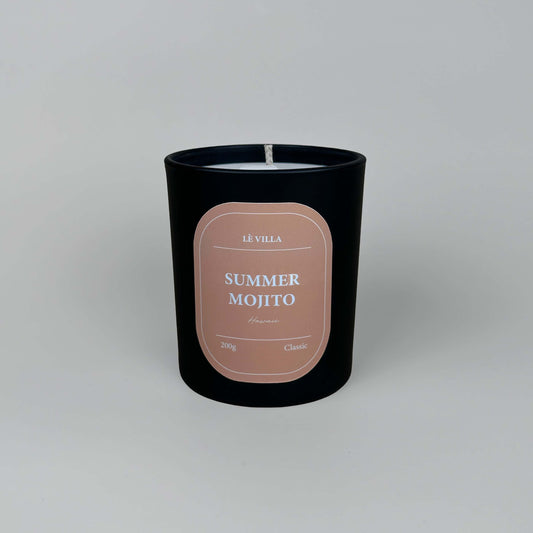 a matte black candle jar with a orange label for hawaii's summer mojito scent